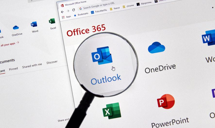 Lupa destaca icono de Outlook en la pantalla de un computador