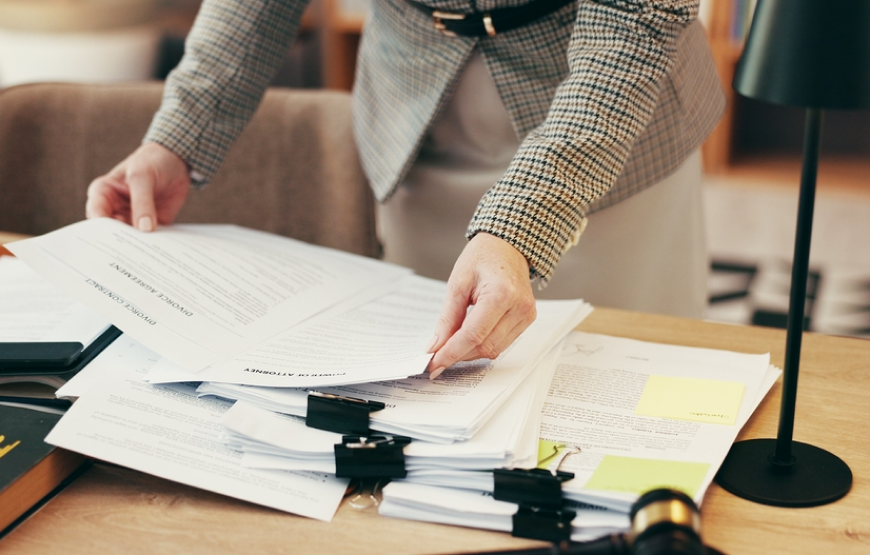 Persona toma revisa documentos sobre una mesa