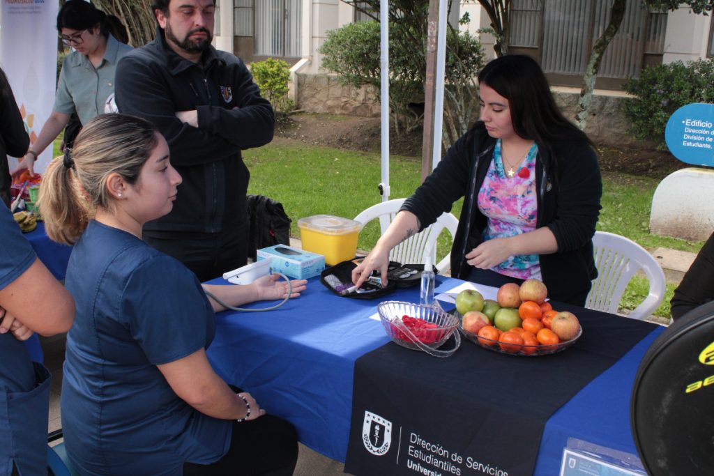 Funcionaria de la Universidad se toma la presión en stan de la Dirección de Servicios Estudiantiles.
