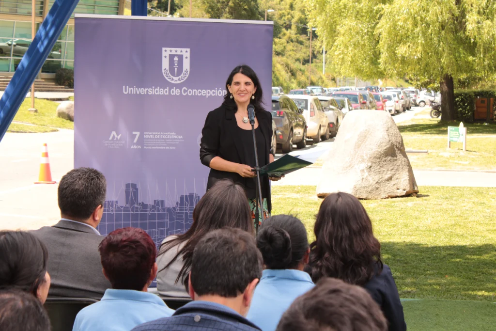 Mujer habla frente a audiencia en la Universidad de Concepción